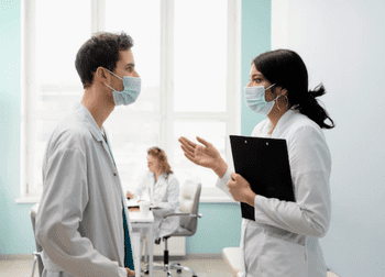 врачи в медицинских масках обсуждают процедуру УБОД